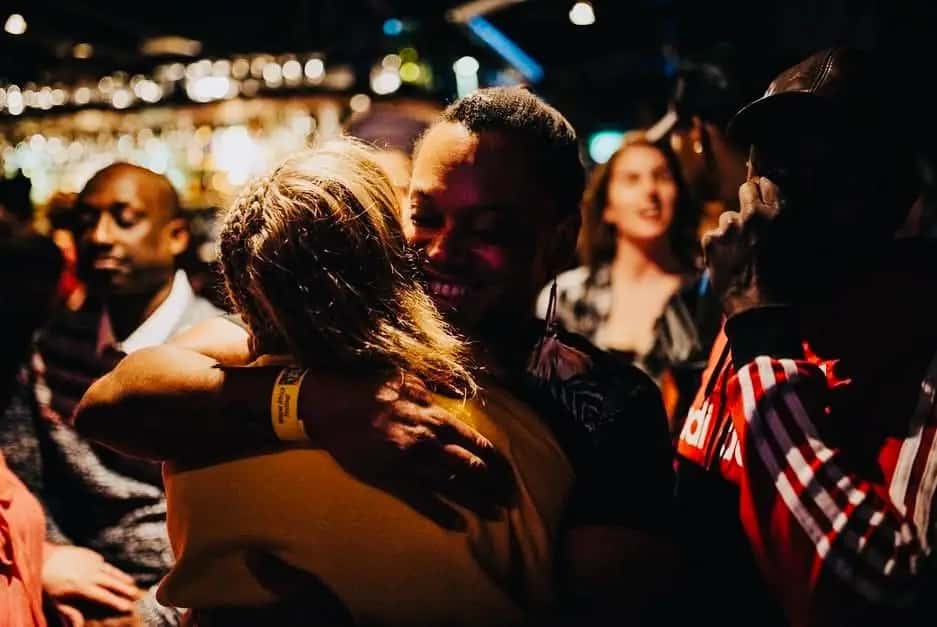 Friends embrace on a busy dance floor