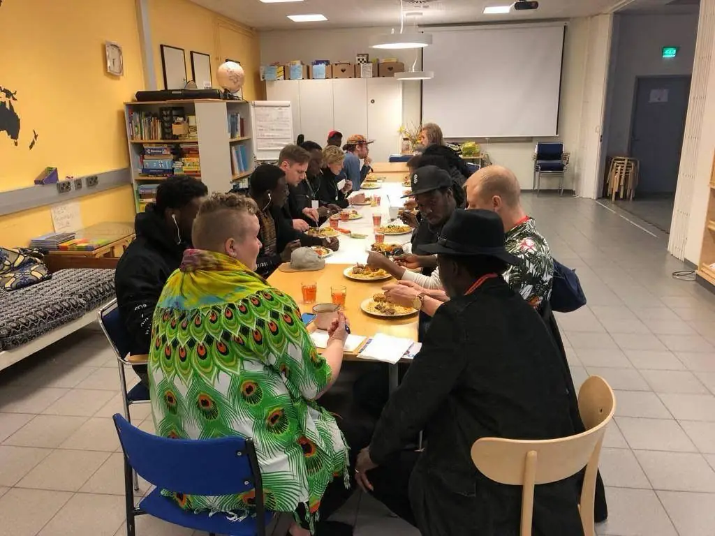 Eri taustoista tulevat ihmiset jakavat pitkän yhteisen illallispöydän