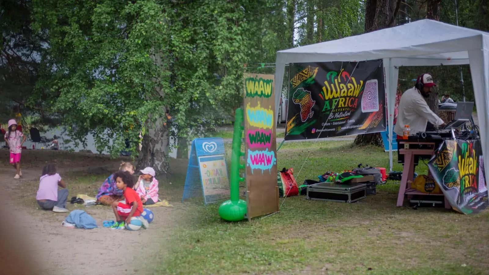 Children play on the grass in front of the WaawAfrica DJ booth